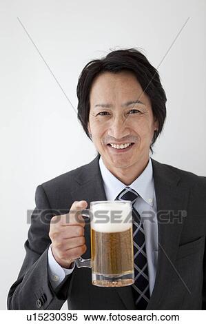 Stock Photography - Businessman holding beer in a mug. Fotosearch
