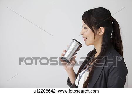 Businesswoman drinking from a stainless steel mug View Large Photo Image Stock Image - Businesswoman drinking from a stainless steel mug. Fotosearch