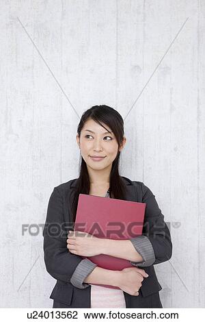 Stock Image - Businesswoman holding a file. Fotosearch