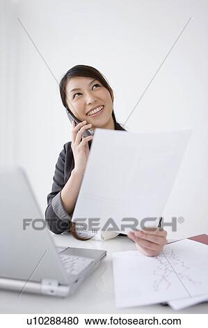 Stock Image - Businesswoman on cell phone. Fotosearch