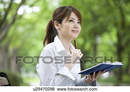 Stock Photo - Businesswoman sitting on park bench . Fotosearch