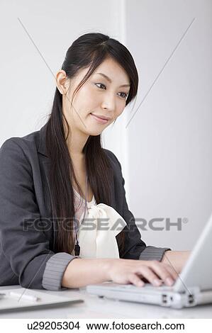 Picture - Businesswoman using laptop. Fotosearch
