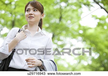 Stock Image - Businesswoman walking outdoors. Fotosearch