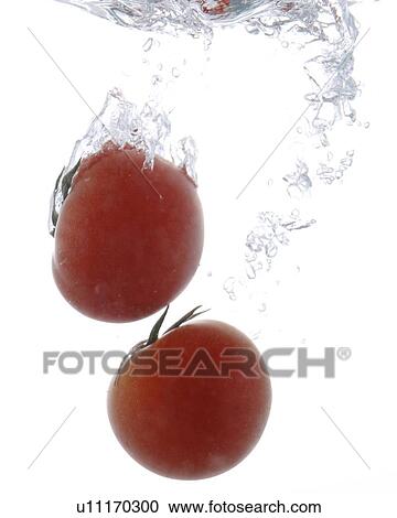 Stock Image - Cherry tomatoes falling into water. Fotosearch