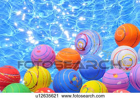 Stock Image - Colorful Balloons Floating on Water. Fotosearch