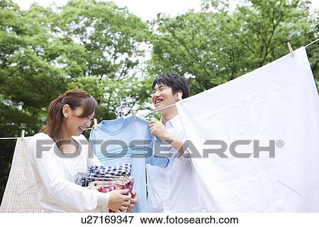 Couple hanging laundry View Large Photo Image Stock Photo - Couple hanging laundry. Fotosearch