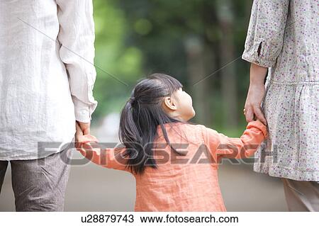 Stock Image - Family holding hands, rear view. Fotosearch
