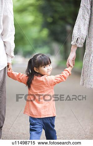 Stock Photography - Family holding hands, rear view. Fotosearch