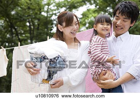 Stock Photograph - Family smiling in front of clothesline. Fotosearch