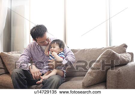 Stock Photography - Father and Baby Boy on Sofa. Fotosearch