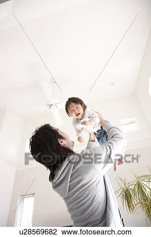 Stock Image - Father Holding Baby Boy Aloft. Fotosearch