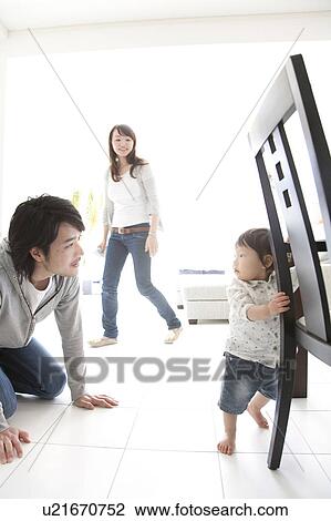 Father Kneeling and Looking at Baby Boy, Mother Walking in Background View Large Photo Image Stock Image - Father Kneeling and Looking at Baby Boy, Mother Walking in Background. Fotosearch