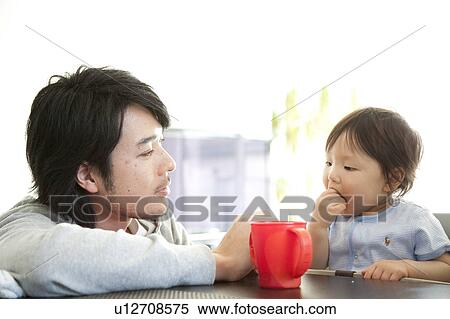 Stock Photography - Father Watching Baby Boy Eating. Fotosearch