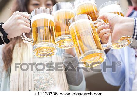 Stock Photograph - Friends toasting with beer. Fotosearch
