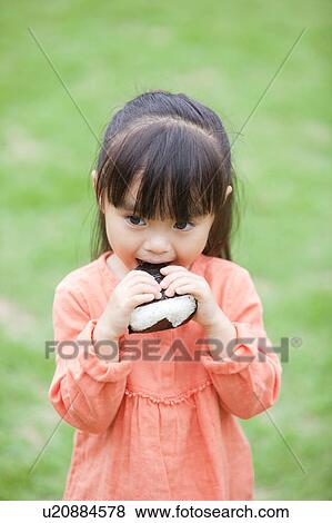 Girl eating rice ball View Large Photo Image Stock Photo - Girl eating rice ball. Fotosearch