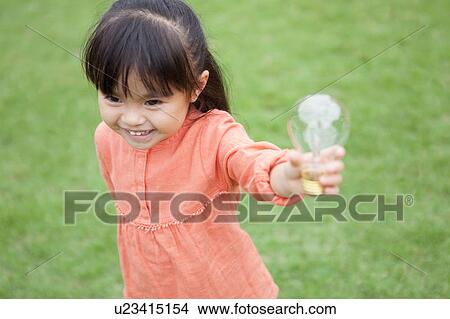 Picture - Girl holding a light bulb. Fotosearch