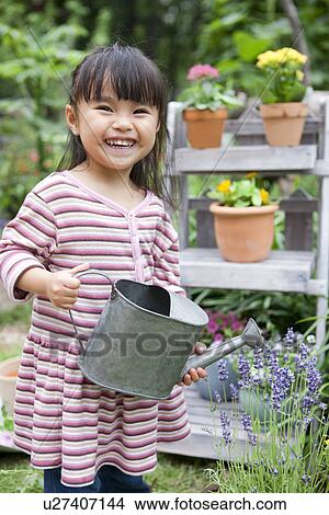Picture - Girl holding a watering can. Fotosearch