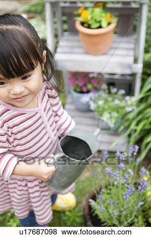 Stock Photo - Girl holding a watering can. Fotosearch