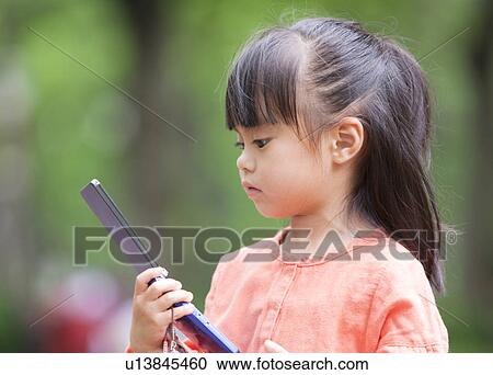 Girl looking at cell phone View Large Photo Image Stock Image - Girl looking at cell phone. Fotosearch