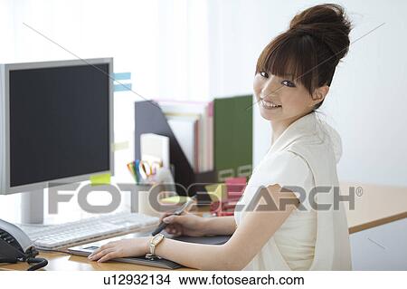 Graphic designer at desk looking at camera View Large Photo Image Picture - Graphic designer at desk looking at camera. Fotosearch