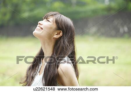 Stock Photo - Happy Young Woman Looking Up. Fotosearch