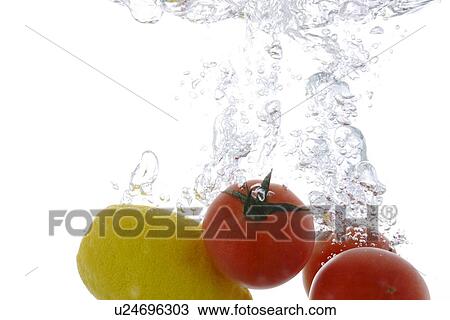 Lemon and cherry tomatoes falling into water View Large Photo Image Stock Image - Lemon and cherry tomatoes falling into water. Fotosearch