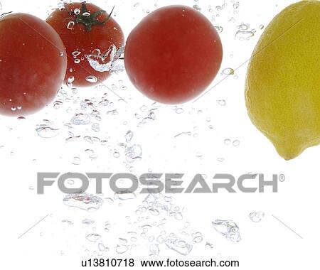 Stock Photo - Lemon and cherry tomatoes falling into water. Fotosearch