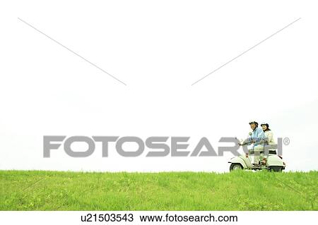 Stock Image - Mature couple on moped. Fotosearch