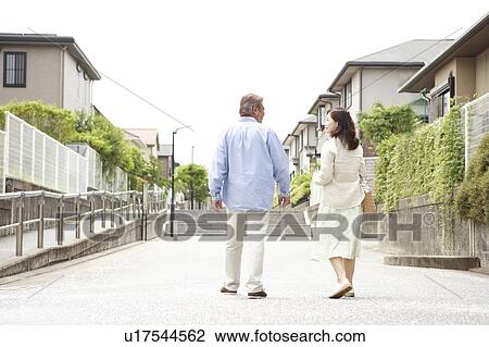 Mature couple walking street, rear view View Large Photo Image Stock Image - Mature couple walking street, rear view. Fotosearch