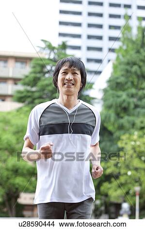 Mature man jogging and listening to music View Large Photo Image Picture - Mature man jogging and listening to music. Fotosearch