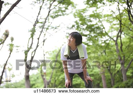 Stock Image - Mature man taking a break from jogging. Fotosearch