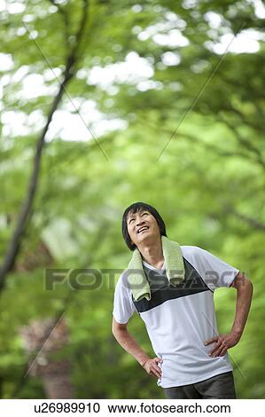 Stock Image - Mature man taking a break from jogging. Fotosearch