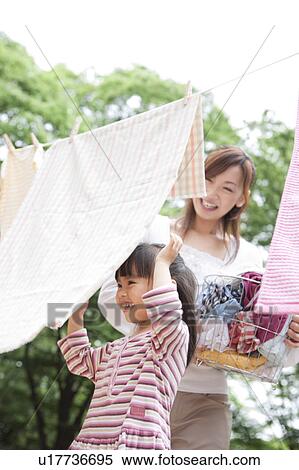 Stock Photography - Mother and daughter doing laundry. Fotosearch
