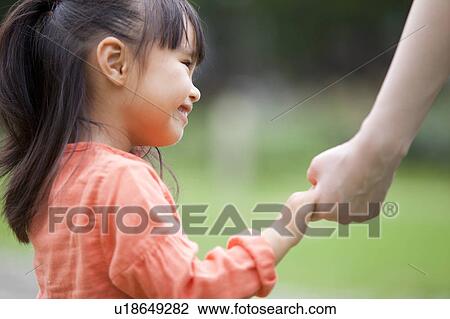 Stock Image - Mother and daughter holding hands. Fotosearch