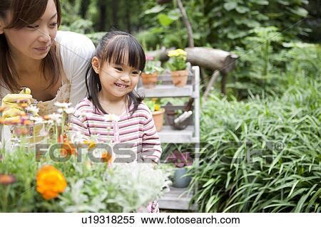 Mother and daughter spraying water on potted flower View Large Photo Image Stock Photography - Mother and daughter spraying water on potted flower. Fotosearch