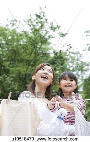 Mother and daughter standing behind clothesline and holding teru teru bozu View Large Photo Image Stock Image - Mother and daughter standing behind clothesline and holding teru teru bozu. Fotosearch