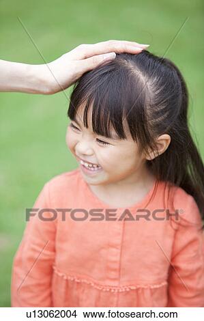 Picture - Mother stroking daughter's head. Fotosearch