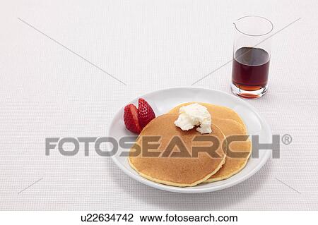 Stock Image - Pancakes with Strawberries and Maple Syrup. Fotosearch