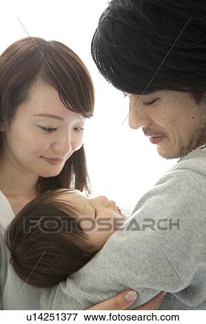 Stock Photo - Parents Looking at Baby Boy Sleeping. Fotosearch