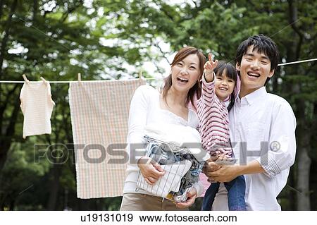 Stock Photo - Portrait of family in front of clothesline. Fotosearch