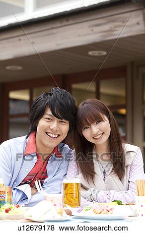 Stock Photo - Portrait of young couple sitting at an outdoor cafe. Fotosearch