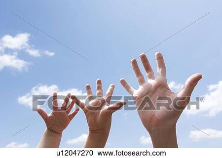 Stock Image - Three Hands Against Sky. Fotosearch
