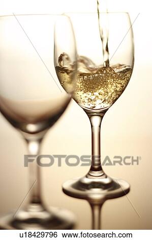 Stock Photograph - White Wine Being Poured Into Glass. Fotosearch
