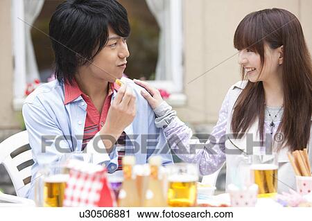 Young couple eating at an outdoor cafe View Large Photo Image Stock Image - Young couple eating at an outdoor cafe. Fotosearch