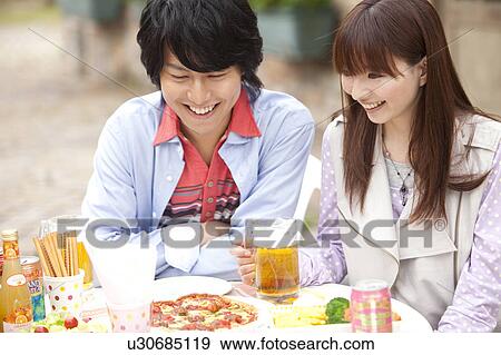 Young couple eating at an outdoors cafe View Large Photo Image Stock Photo - Young couple eating at an outdoors cafe. Fotosearch