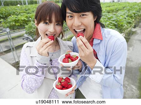Young couple eating bowl of strawberries View Large Photo Image Stock Image - Young couple eating bowl of strawberries. Fotosearch
