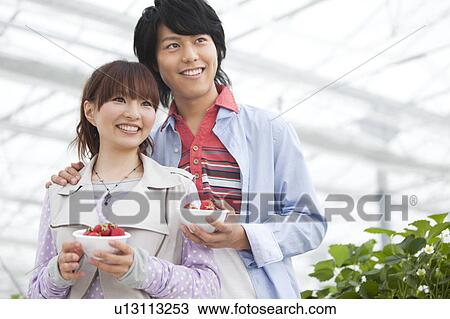 Young couple holding bowl of strawberries View Large Photo Image Stock Image - Young couple holding bowl of strawberries. Fotosearch