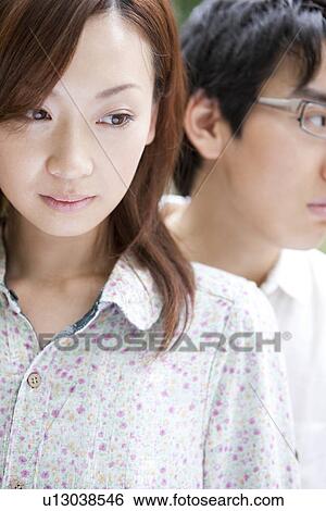Stock Photograph - Young couple looking away, focus on foreground. Fotosearch