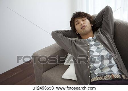 Young man lying on sofa sleeping View Large Photo Image Stock Image - Young man lying on sofa sleeping. Fotosearch