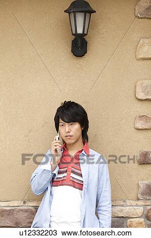 Stock Image - Young man on cell phone. Fotosearch